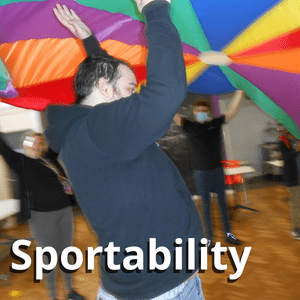 staff and students lifting a colourful parachute 