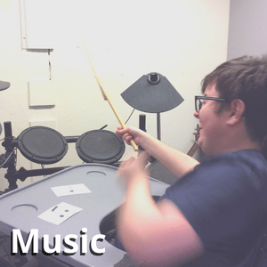 A student playing the drums in a music lesson